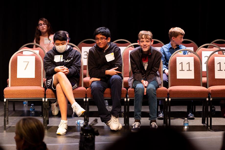 Chandler Unified Spelling Bee competitors smile because one of the three students pictured correctly spelled a word and surprised himself